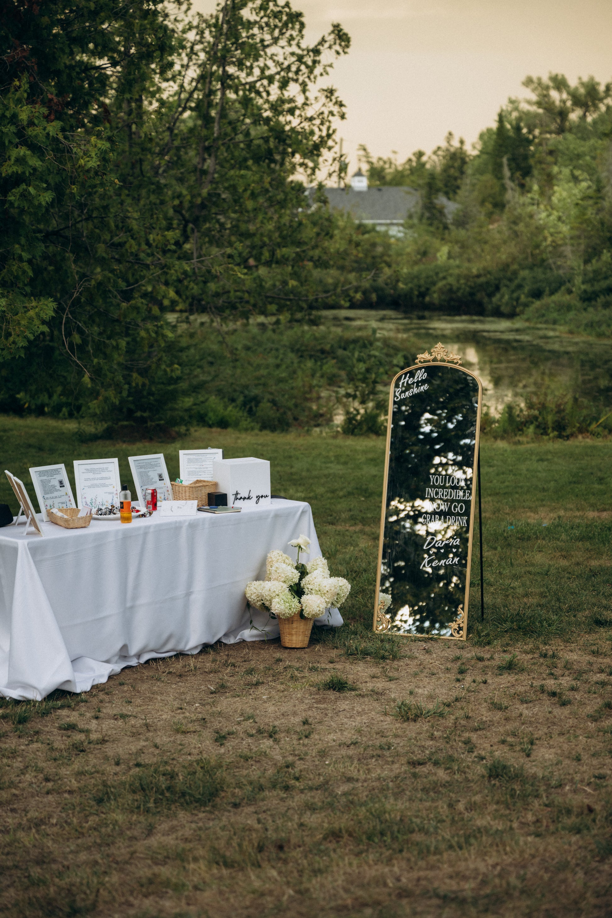 Outdoor setup with a table, mirror, and flowers in a natural setting