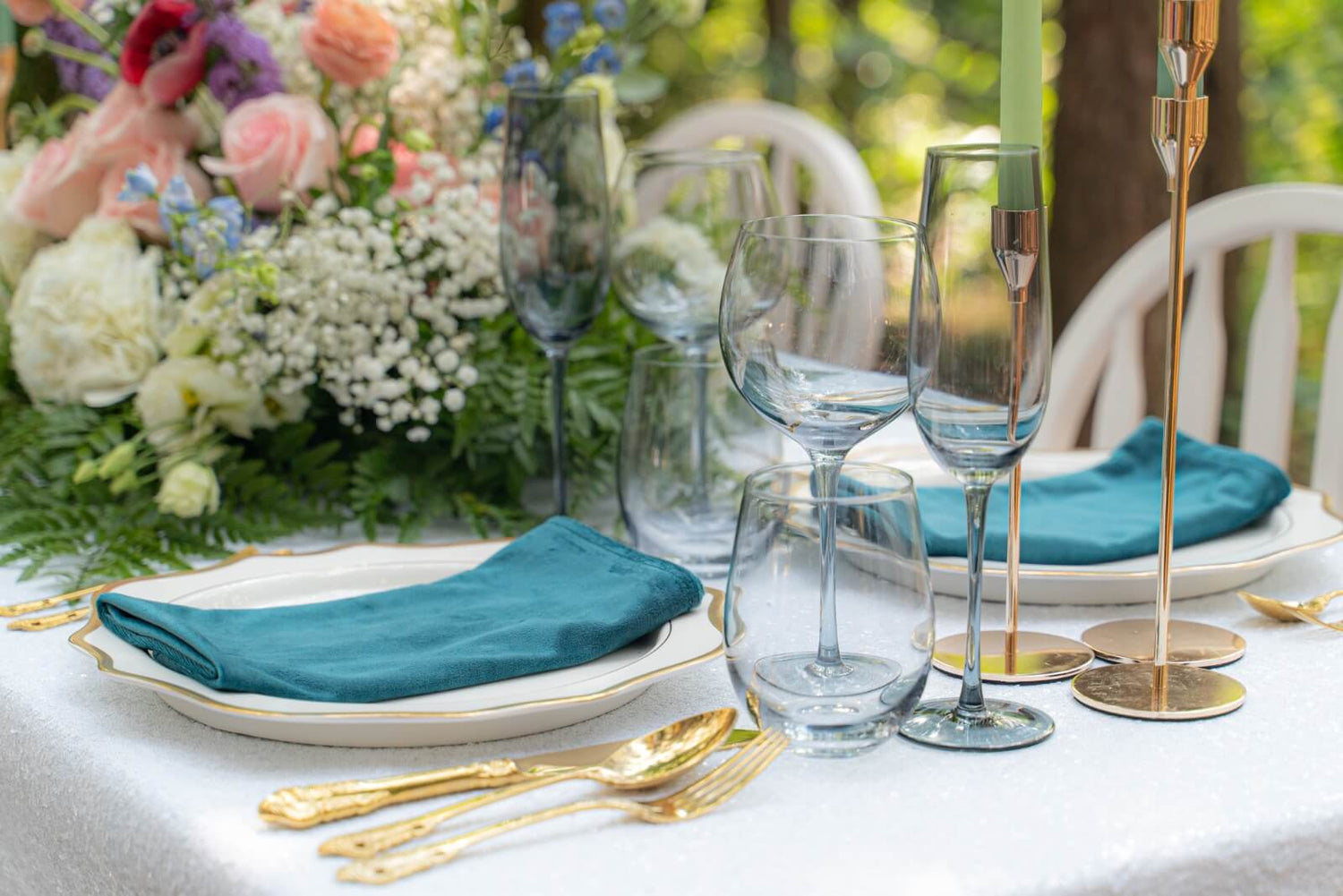 Elegant table setup featuring luxury charger plates, flatware, glassware, napkins, tablecloth, and a stylish table runner from Pisani Wedding Decor rentals.