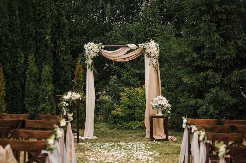 Decorative arch with flowers and fabric in a garden setting