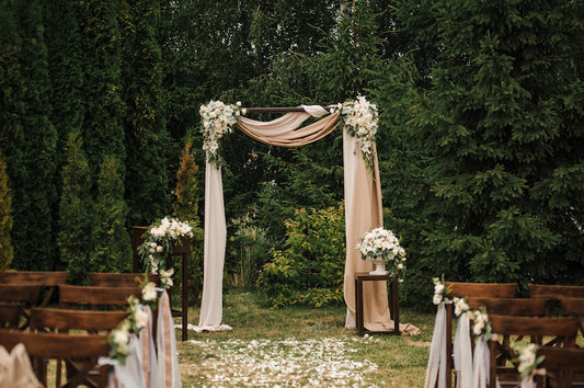 Decorative arch with flowers and fabric in a garden setting