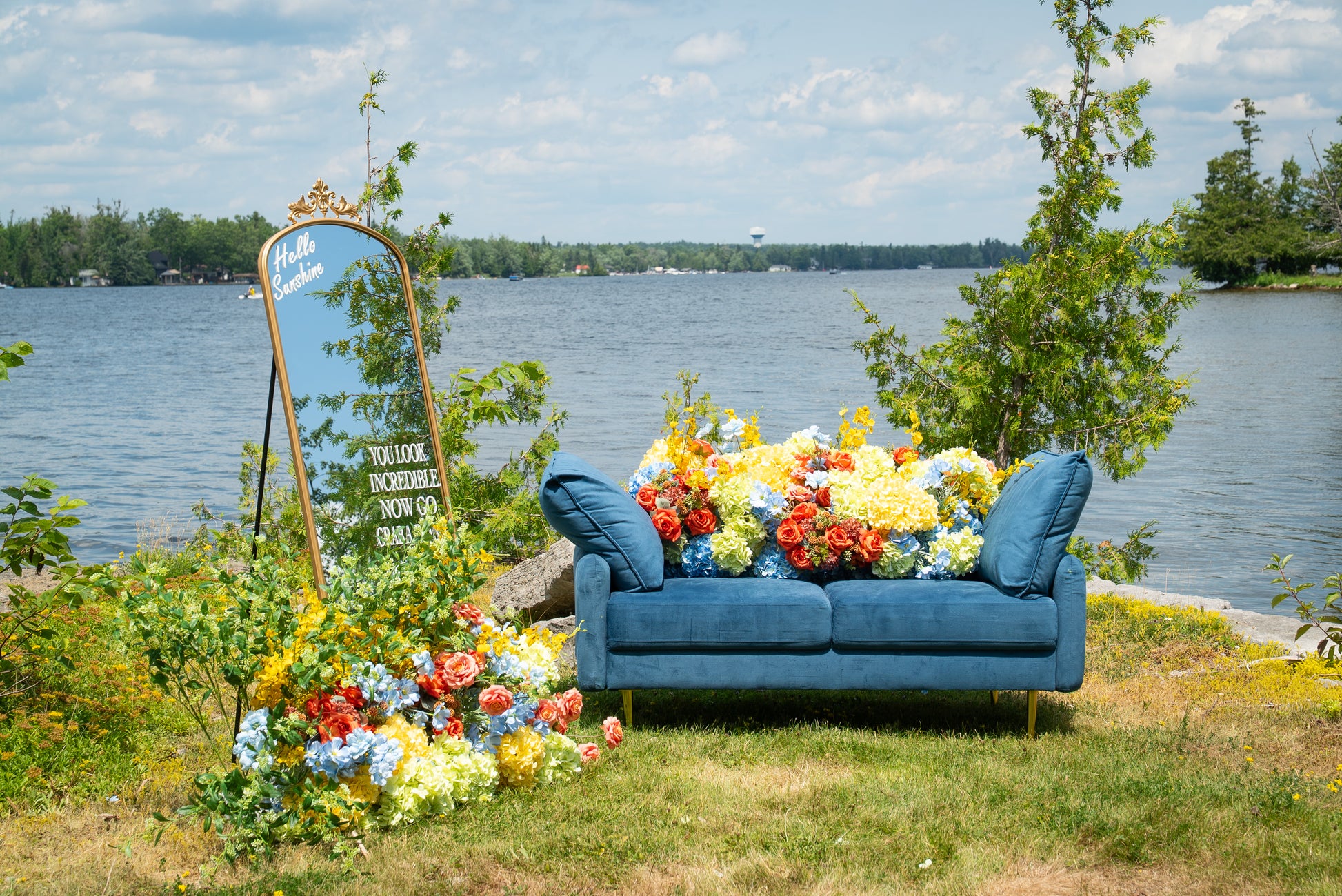 Blue sofa with colorful flowers by a lake