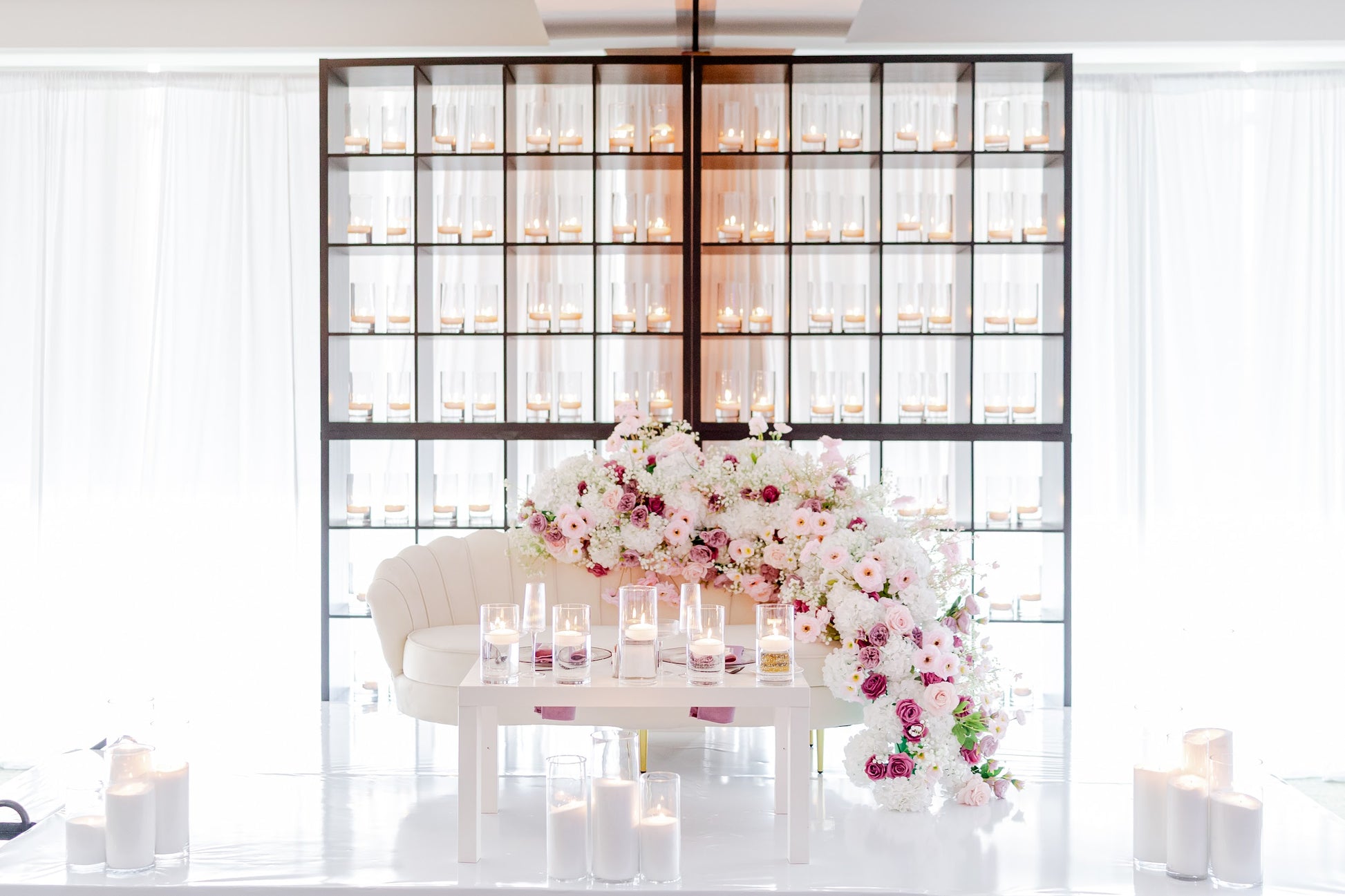 Decorative setup with flowers and candles in a room with a glass partition.