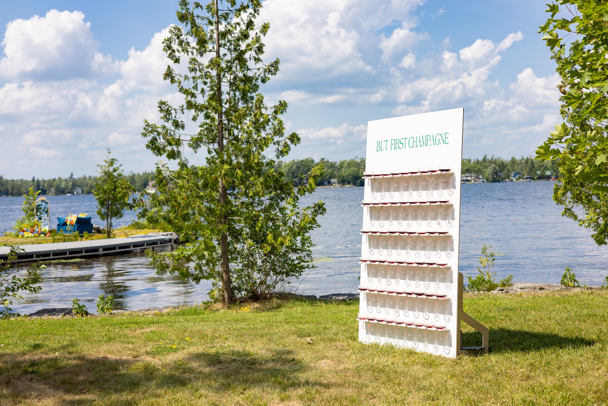White display stand with 'Best First Impressions' text by a lake on a sunny day
