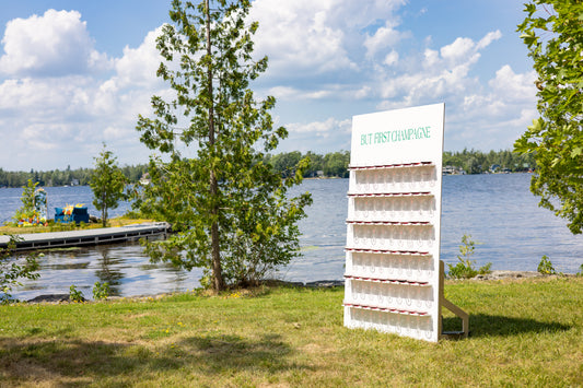 White display stand with 'Best First Impressions' text by a lake on a sunny day