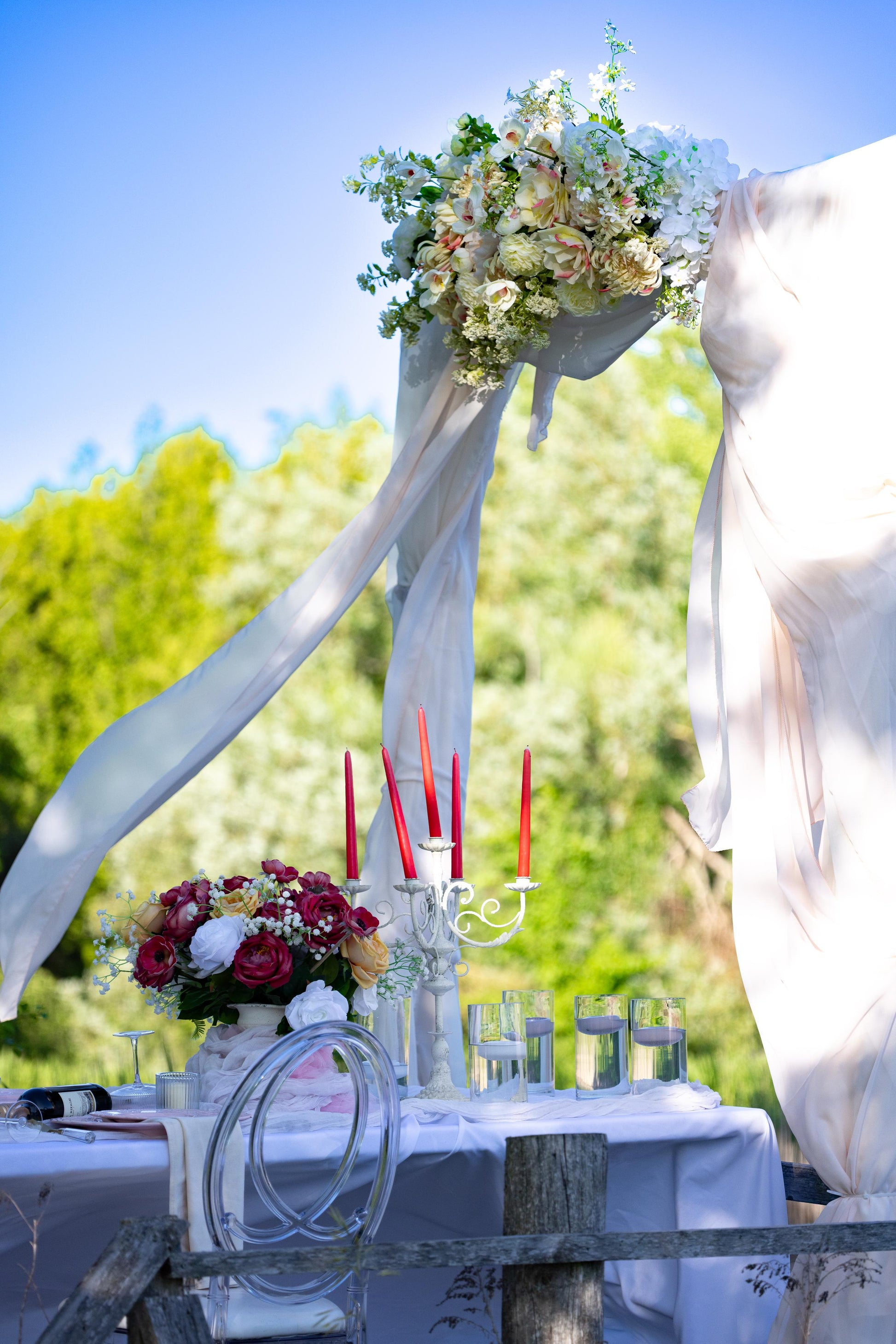 Decorative table setup with flowers and candles outdoors